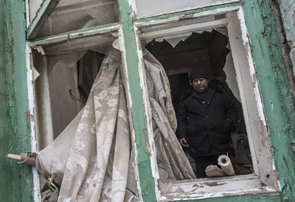 Мужчина в своем доме, поврежденном в результате обстрела