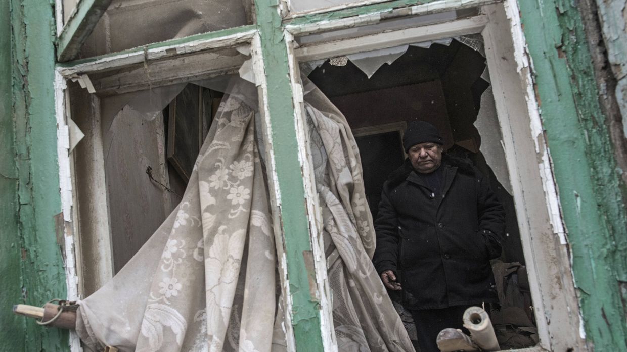 Мужчина в своем доме, поврежденном в результате обстрела Мужчина в своем доме, поврежденном в результате обстрела