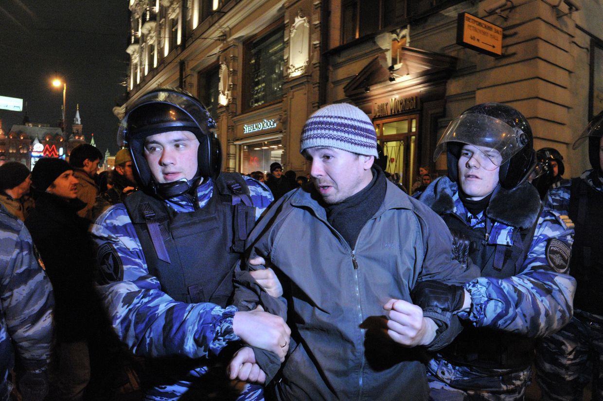 Сотрудники полиции задерживают участника акции протеста на Манежной площади