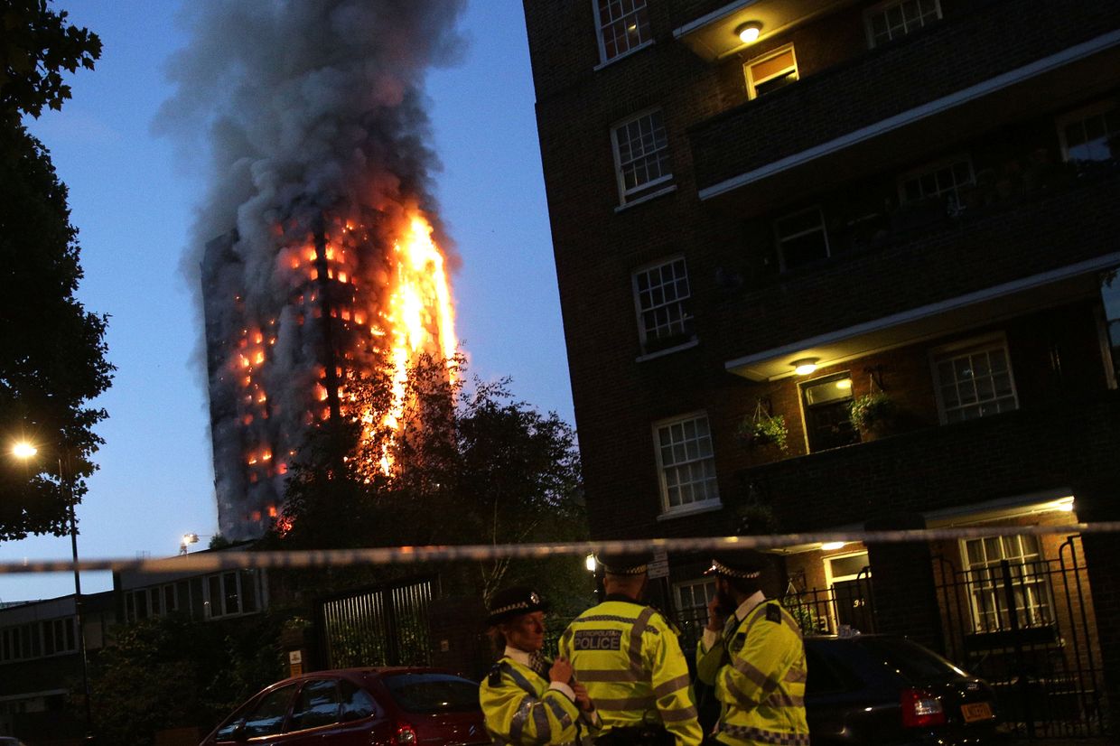 Сотрудники полиции на месте пожара в многоэтажном доме Grenfell Tower в Лондоне. 14 июня 2017