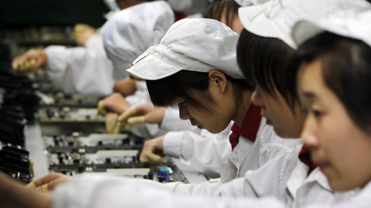 Работники на производственной линии завода Foxconn в Шэньчжэнь Работники на производственной линии завода Foxconn в Шэньчжэнь