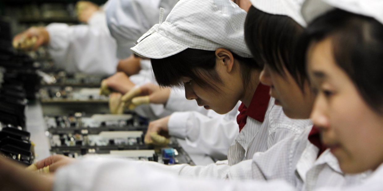 Работники на производственной линии завода Foxconn в Шэньчжэнь