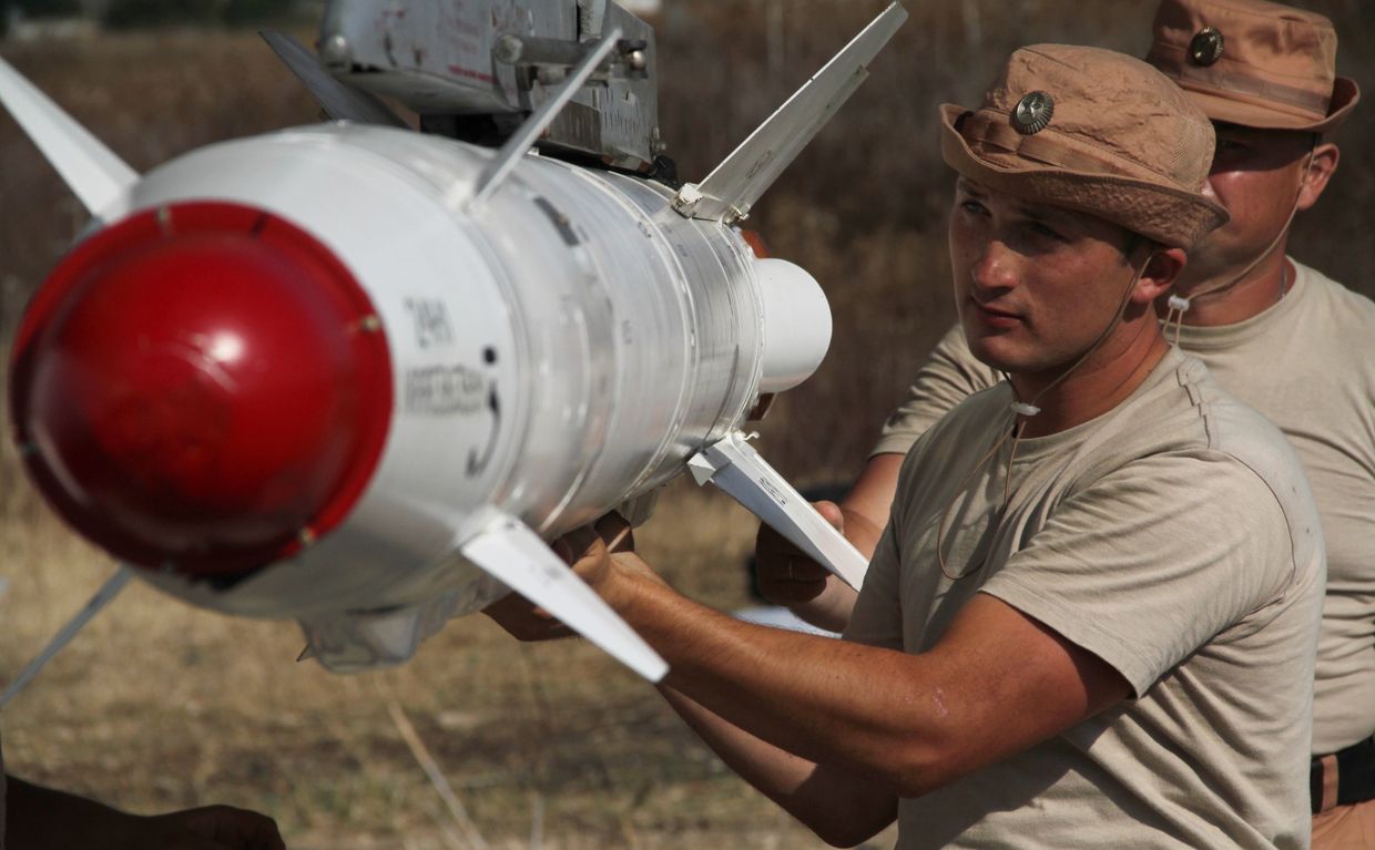 Российские военные подвешивают высокоточную ракету Х-25 к самолету Су-24 на авиабазе Хмеймим в Сирии