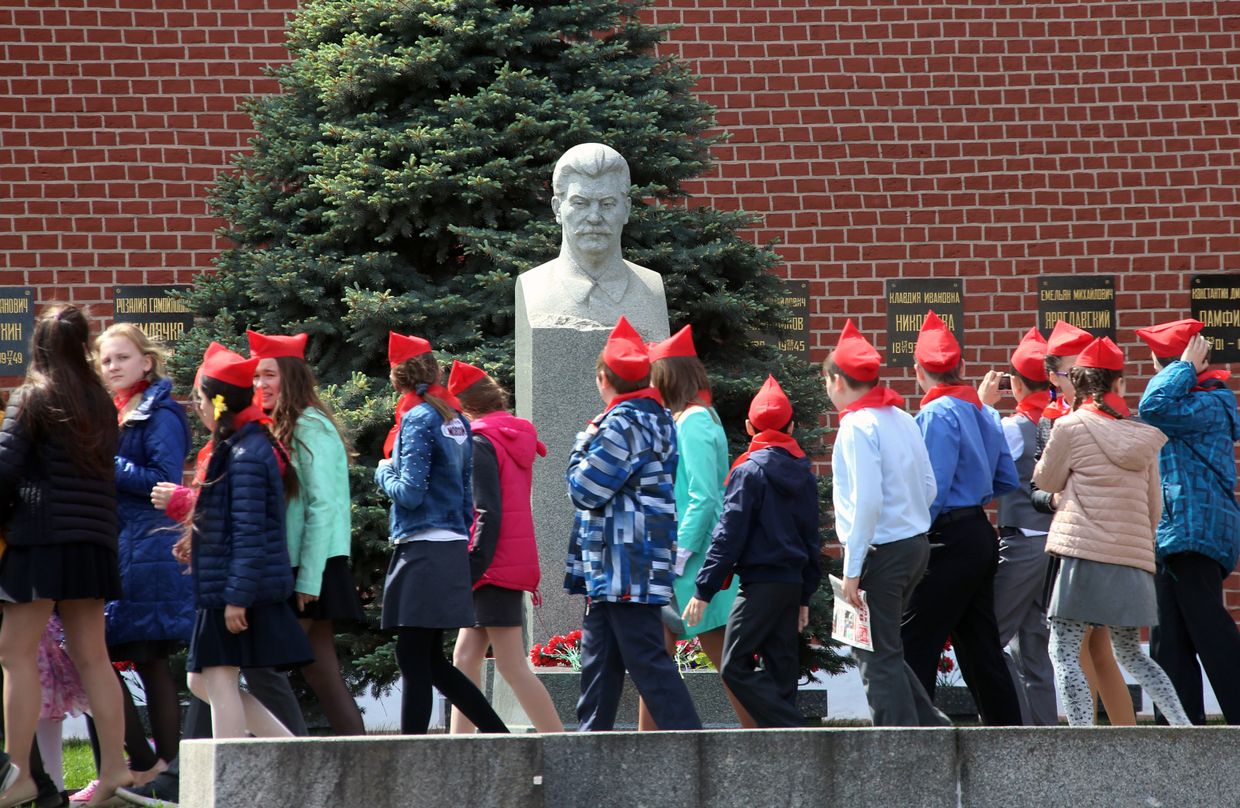 Школьники проходят мимо бюста  Иосифа Сталина