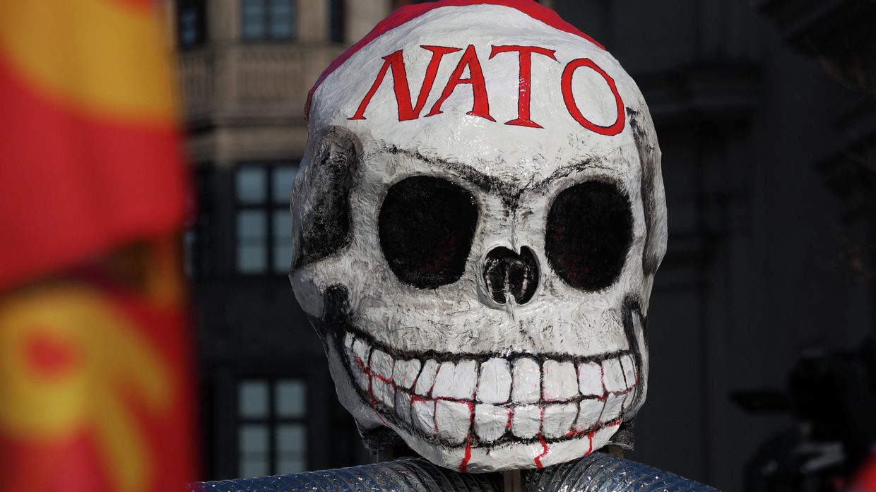 Маска на демонстрации против политики НАТО на площади у городской ратуши в Мюнхене