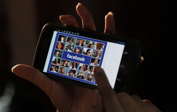 Facebook на экране мобильного телефона Facebook на экране мобильного телефона