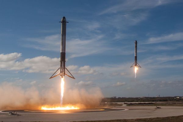 Ракеты-носители Falcon возвращаются для посадки в космическом центре Кеннеди Ракеты-носители Falcon возвращаются для посадки в космическом центре Кеннеди