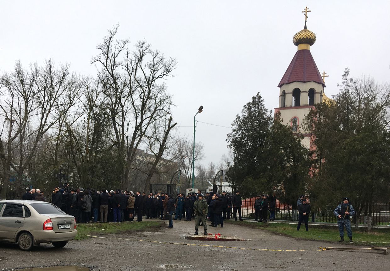 Жители несут цветы к Свято-Георгиевскому храму в Кизляре