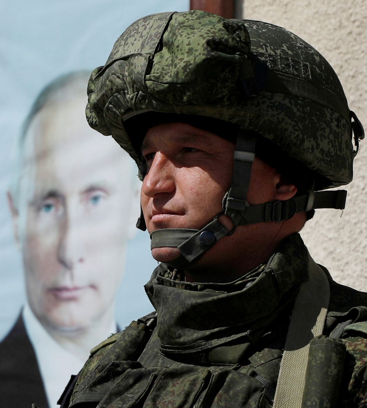 Российский солдат рядом с портретом президента России Владимира Путина в Дамаске
