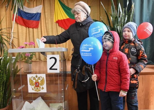 Женщина опускает бюллетень в урну на выборах президента Российской Федерации на избирательном участке в Чите. 18 марта 2018
