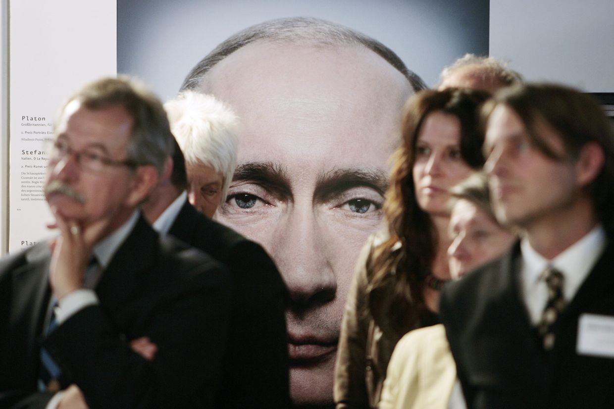 Посетители стоят перед фотографией Владимира Путина
