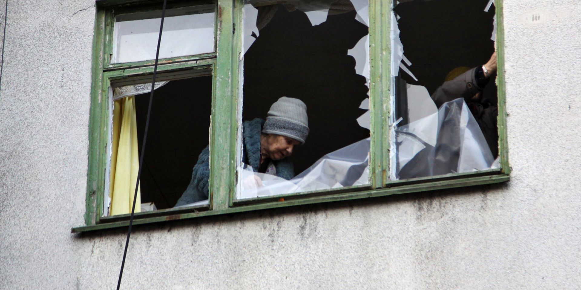 Женщина у окна жилого дома в центре города Ясиноватая, пострадавшего в результате обстрела - ИноСМИ, 1920, 23.05.2023