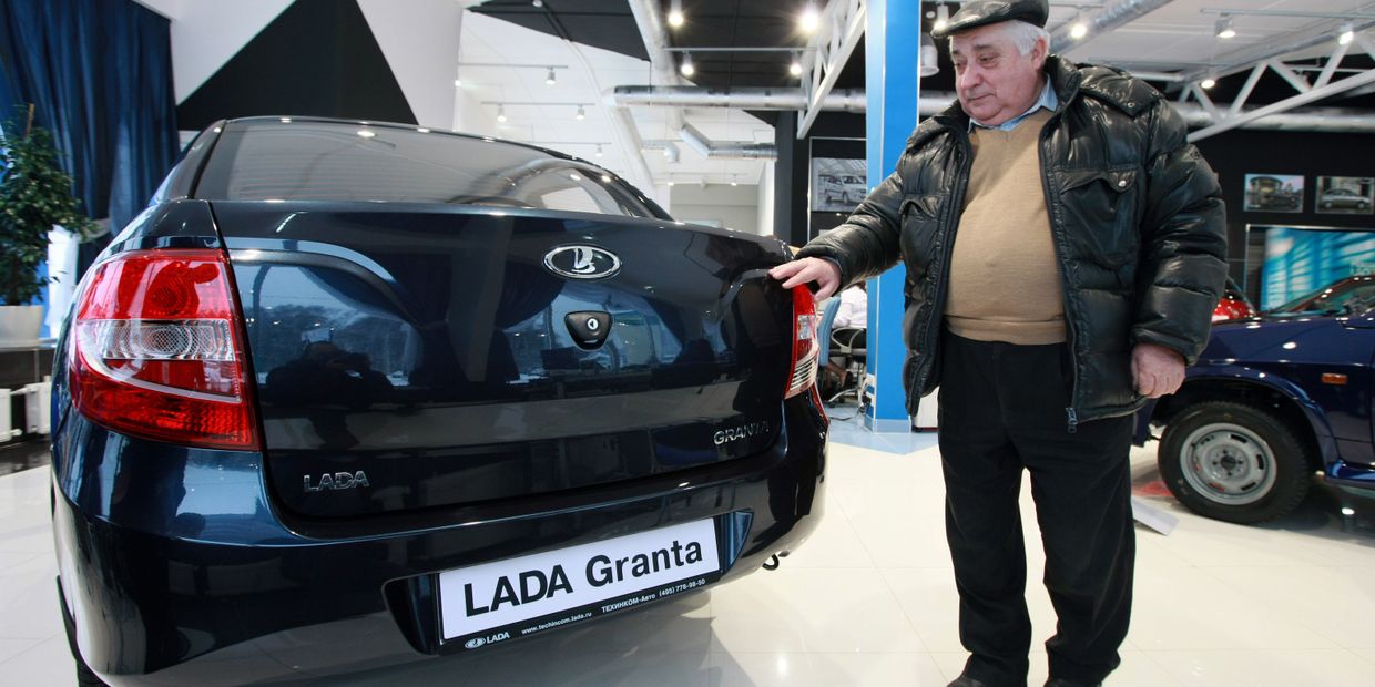 Мужчина выбирает автомобиль Лада Гранта в автосалоне Мужчина выбирает автомобиль Лада Гранта в автосалоне