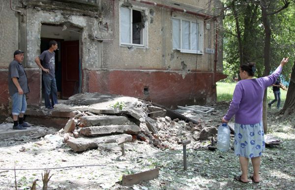 Жители во дворе жилого дома, пострадавшего в результате обстрела, в поселке Горловка Донецкой области Жители во дворе жилого дома, пострадавшего в результате обстрела, в поселке Горловка Донецкой области
