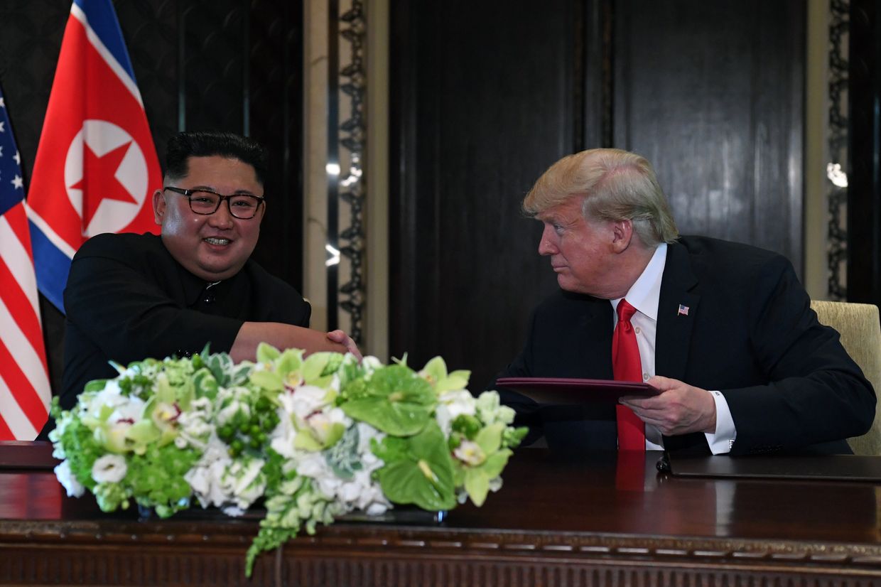 Лидер КНДР Ким Чен Ын и президент США Дональд Трамп во время церемонии подписания документов по итогам встречи в Сингапуре. 12 июня 2018