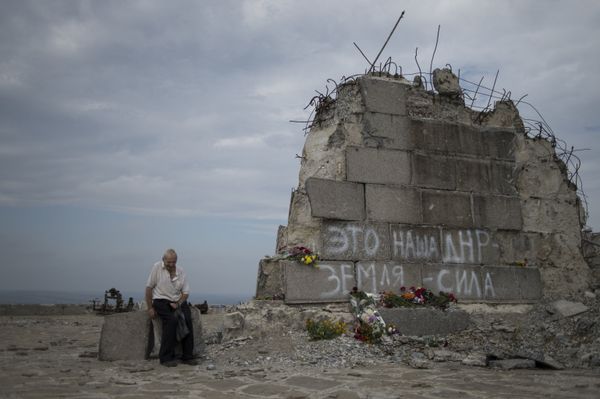 Мужчина у мемориала на кургане Саур-Могила в Донецкой области