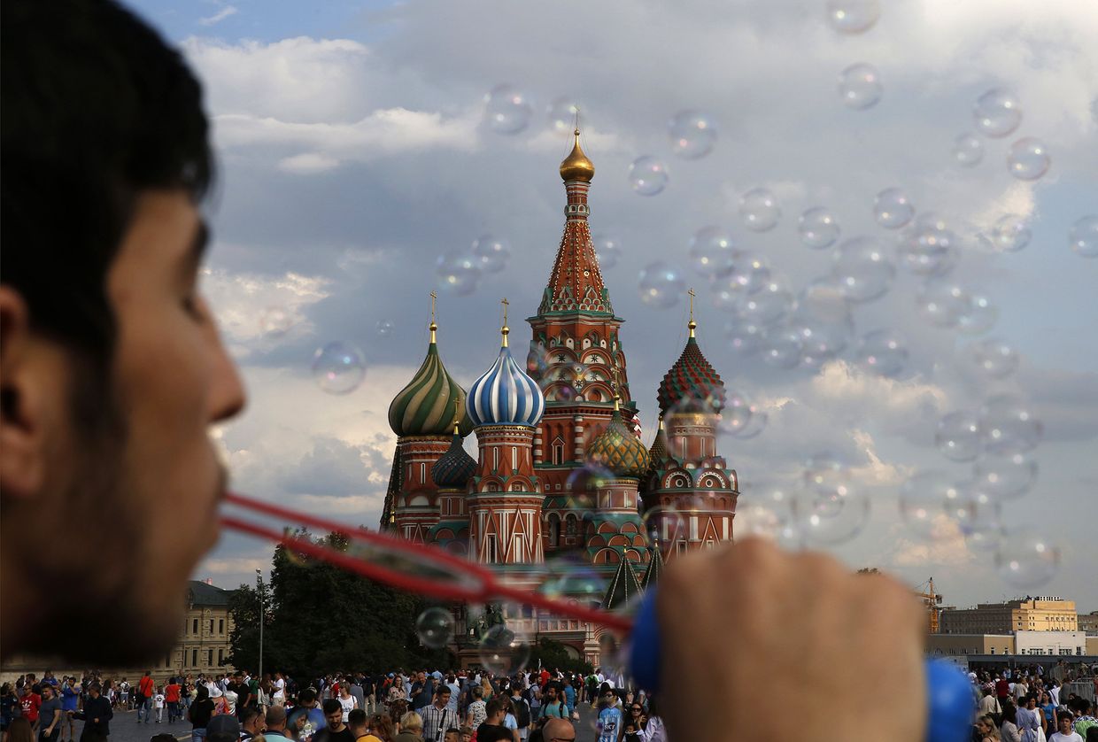 Молодой человек пускает мыльные пузыри на Красной площади в Москве