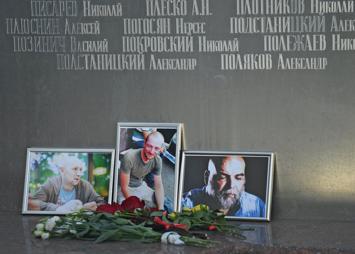 Цветы у фотографий погибших в Центральноафриканской Республике журналистов: Орхана Джемаля, Кирилла Радченко и Александра Расторгуева возле Дома журналистов в Москве. 1 августа 2018