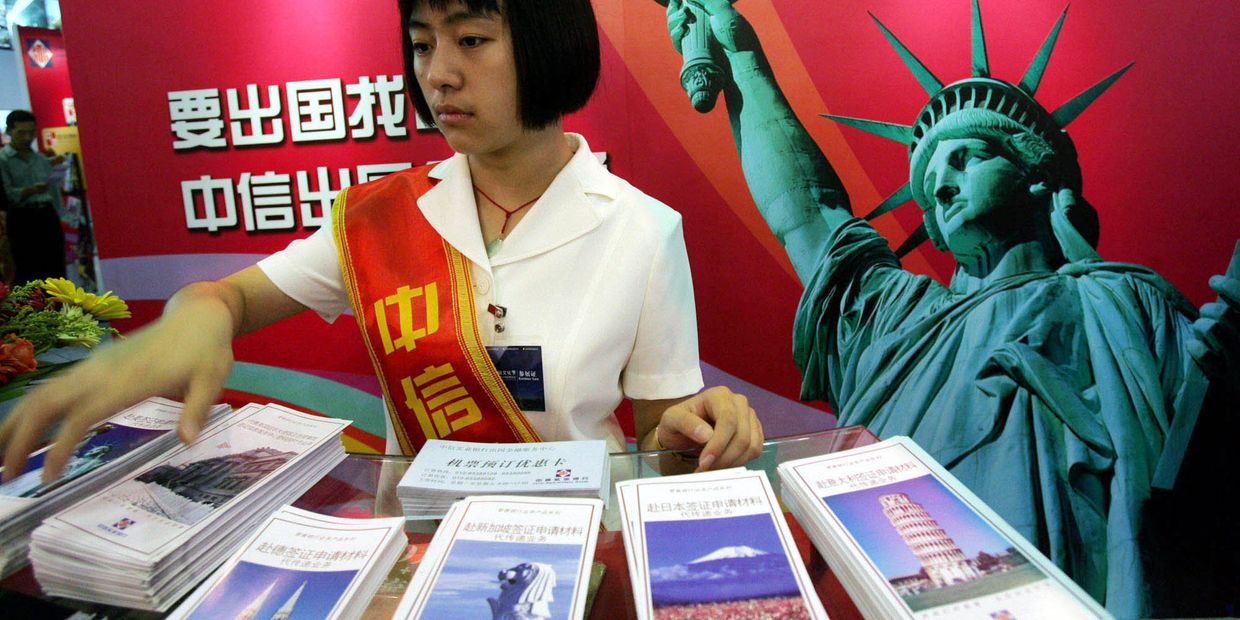 Девушка у стенда китайской компании CITIC на Международной выставке финансовой культуры в Пекине, КНР