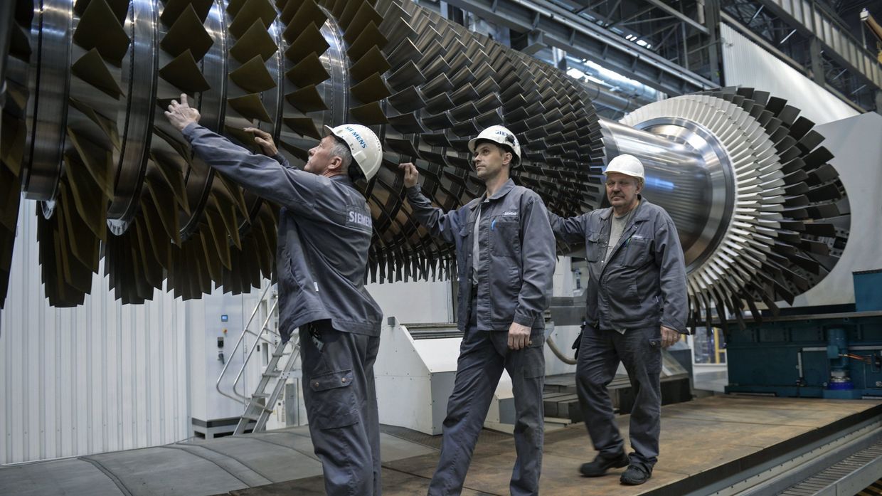 Рабочие ООО Сименс технологии газовых турбин осматривают ротор с лопатками в цехе по восстановлению лопаток газовых турбин