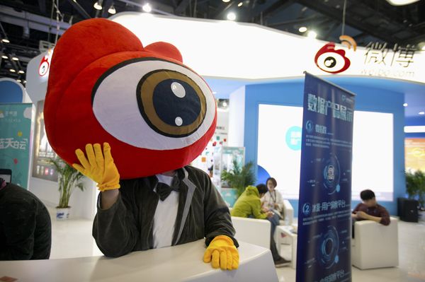 Сотрудник на стенде китайского сайта микроблогов Sina Weibo