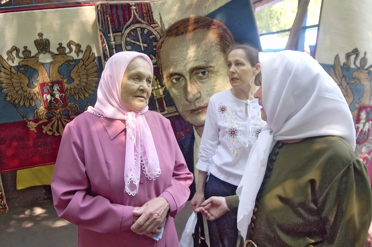Пенсионеры Самары на фоне ковра с изображением президента России Владимира Путина