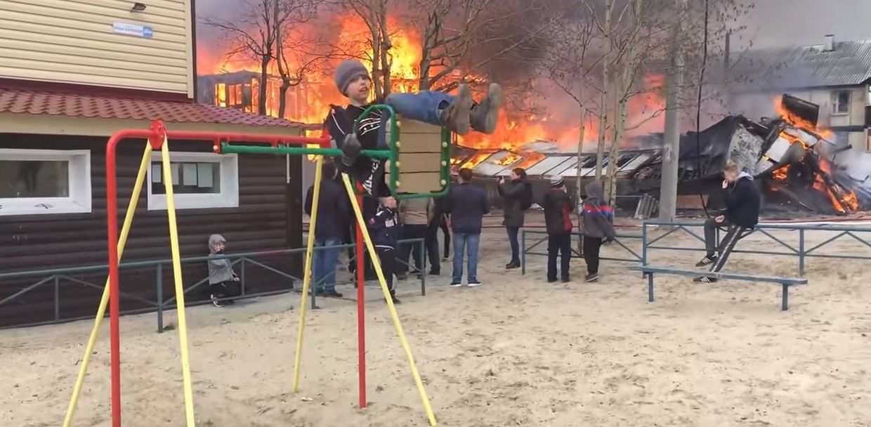 Мальчик из города Ноябрьск, качающийся на качелях рядом с горящим домом!