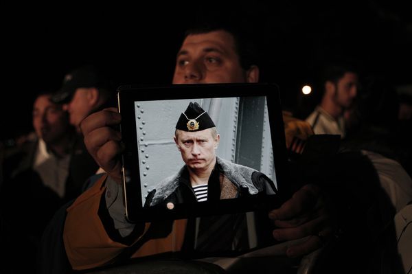 Протестующие с фотографией президента России Владимира Путина во время акции протеста у здания кипрского парламента Протестующие с фотографией президента России Владимира Путина во время акции протеста у здания кипрского парламента
