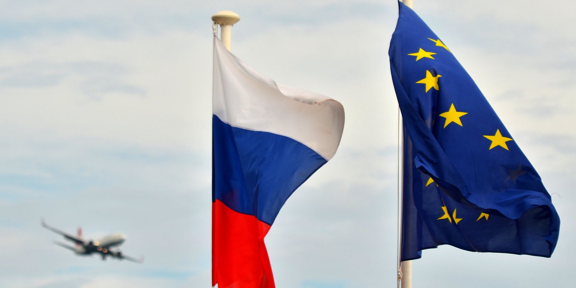 Флаги России, ЕС и Франции на набережной Ниццы. На дальнем плане - самолет заходит на посадку в международный аэропорт Ниццы. - ИноСМИ, 1920, 26.03.2025