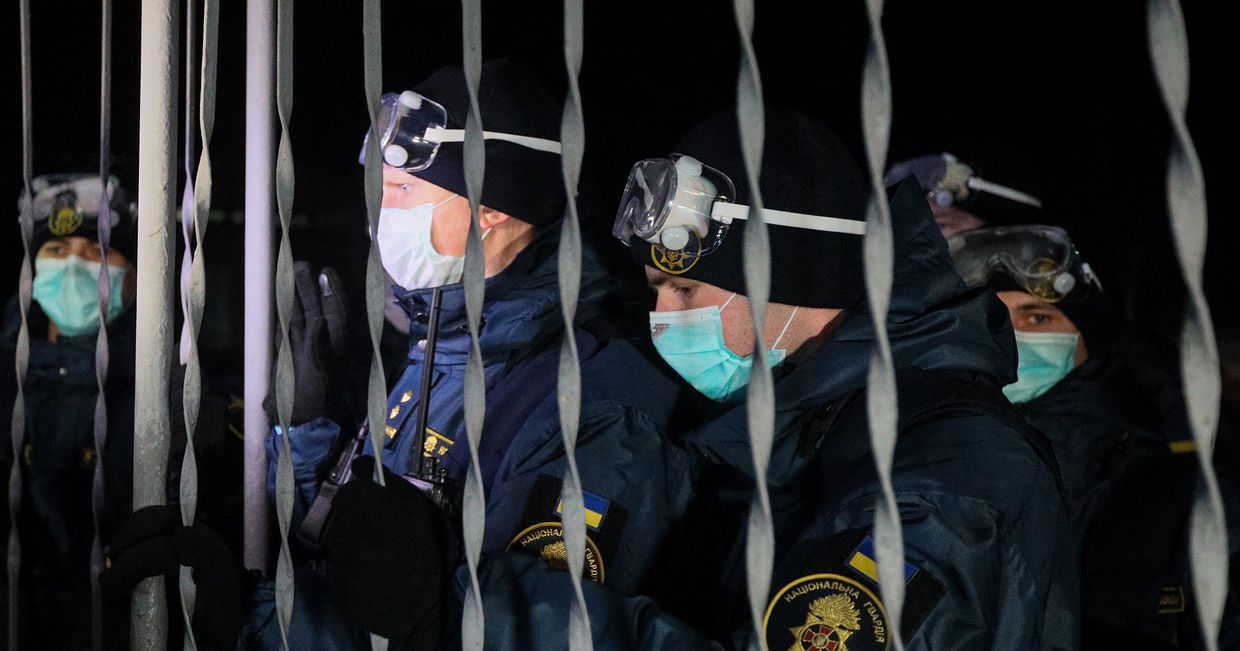 Военнослужащие национальной гвардии украины у автобуса с эвакуированными из китайского города Ухань в поселке Новые Санжары на Украине