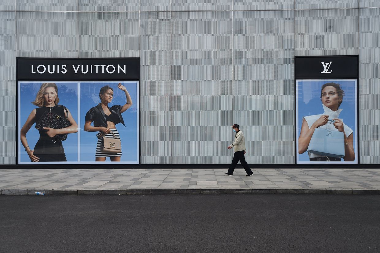 Мужчина идет мимо магазина Louis Vuitton в Ухане, Китай