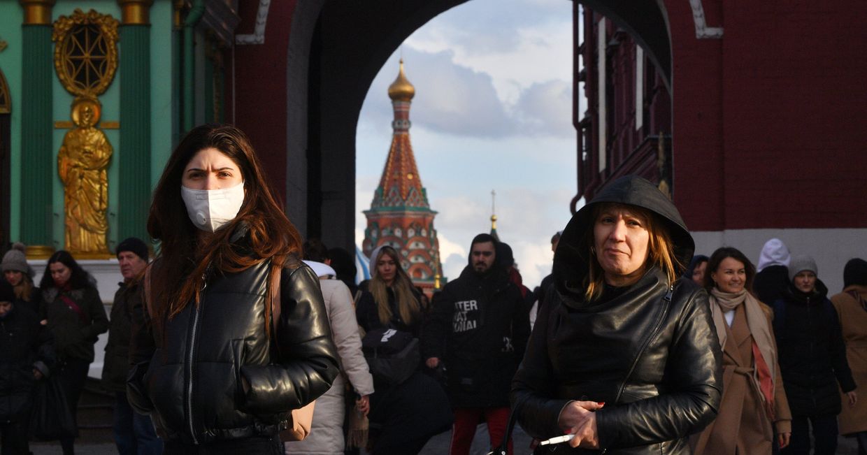 Люди проходят через Воскресенские ворота, ведущие на Красную площадь, в Москве