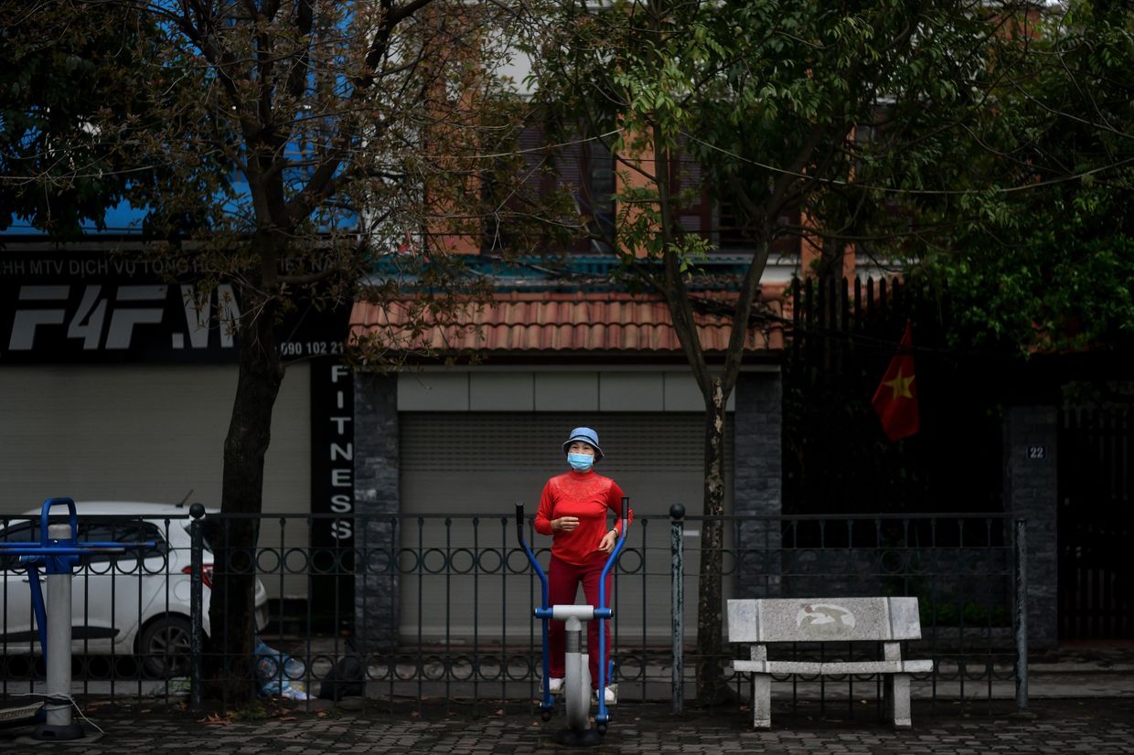 Человек занимается фитнесом, не снимая маски. Ханой, Вьетнам