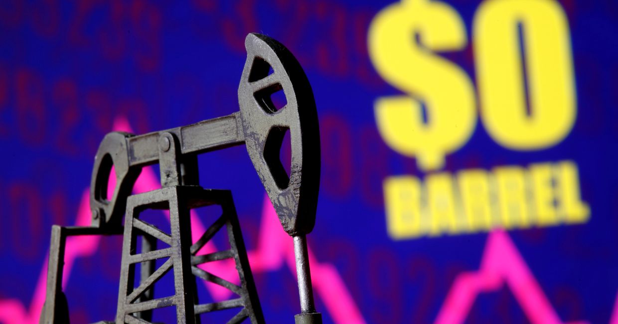 Муляж нефтяного насоса на фоне надписи «0 долларов за баррель»