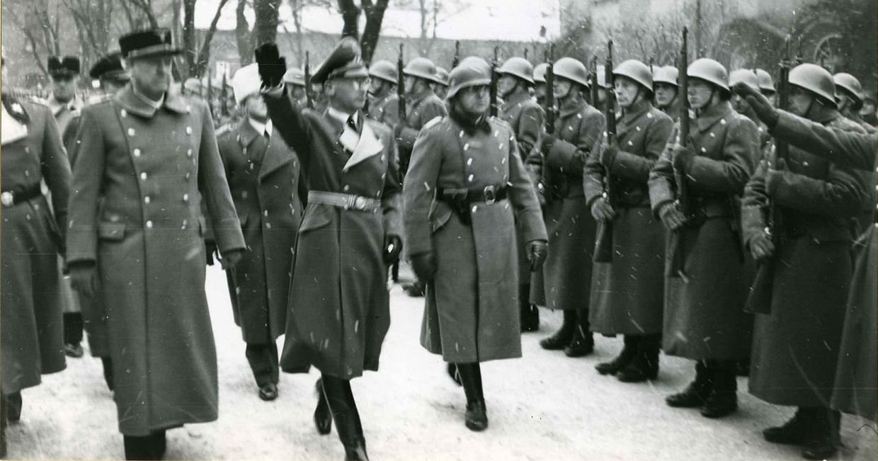 Видкун Квислинг (слева) и рейхскомиссар Йозеф Тербовен инспектируют строй полицейских офицеров в 1942 году