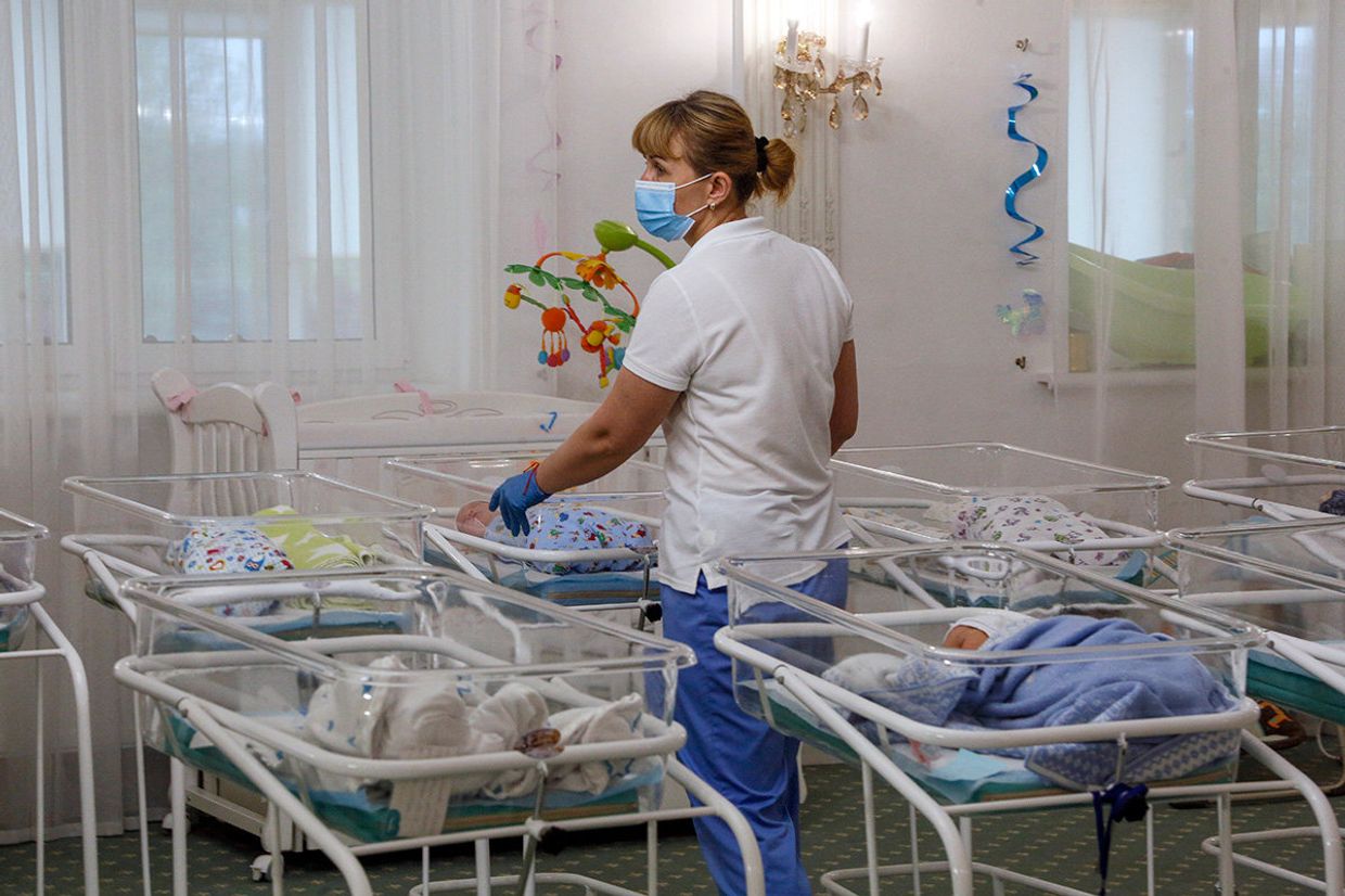 Медсестра в заботится о младенцах, рожденных суррогатными матерями в Киеве