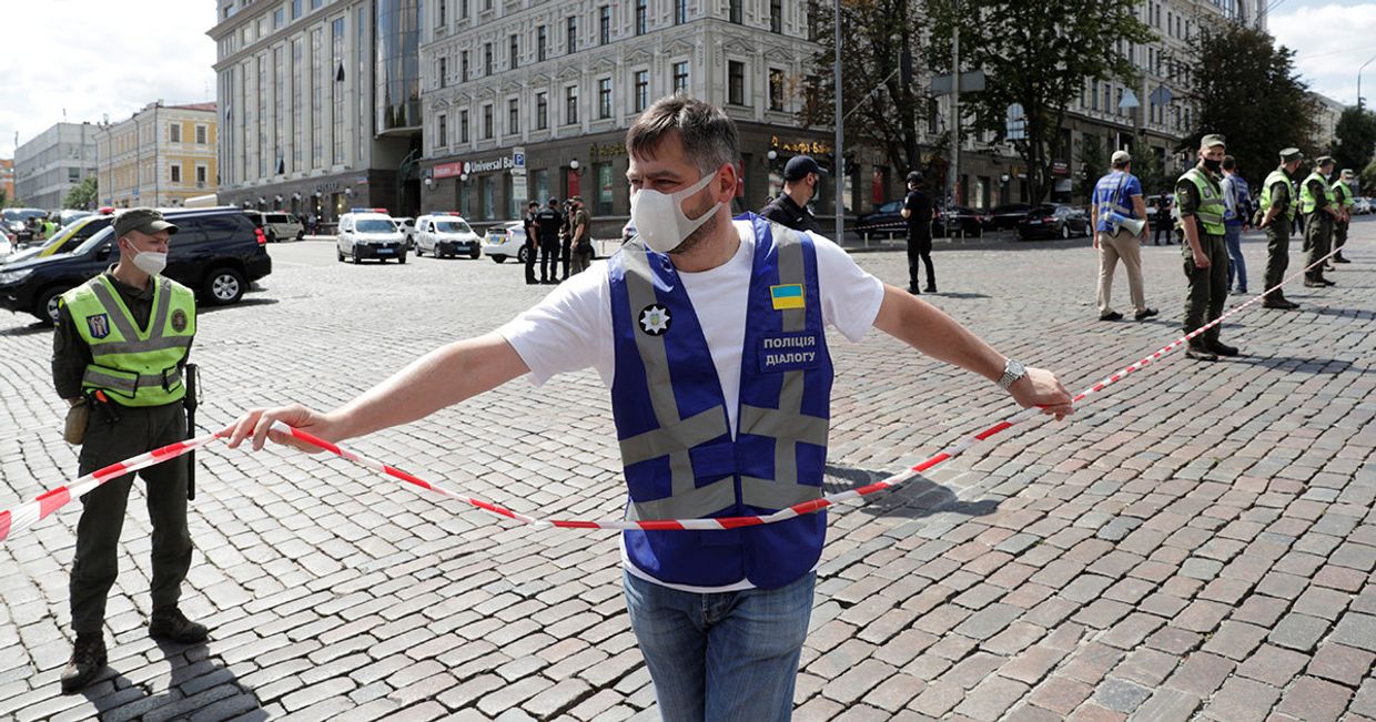 Сотрудники правоохранительных органов у отделения банке в Киеве, где неизвестный угрожает взорвать бомбу