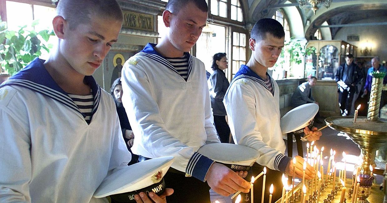 23 августа 2000. Российские моряки ставят свечи в память о погибших членах экипажа подводной лодки «Курск»