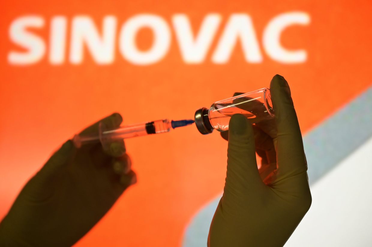 Шприц и ампула на фоне логотипа SinoVac