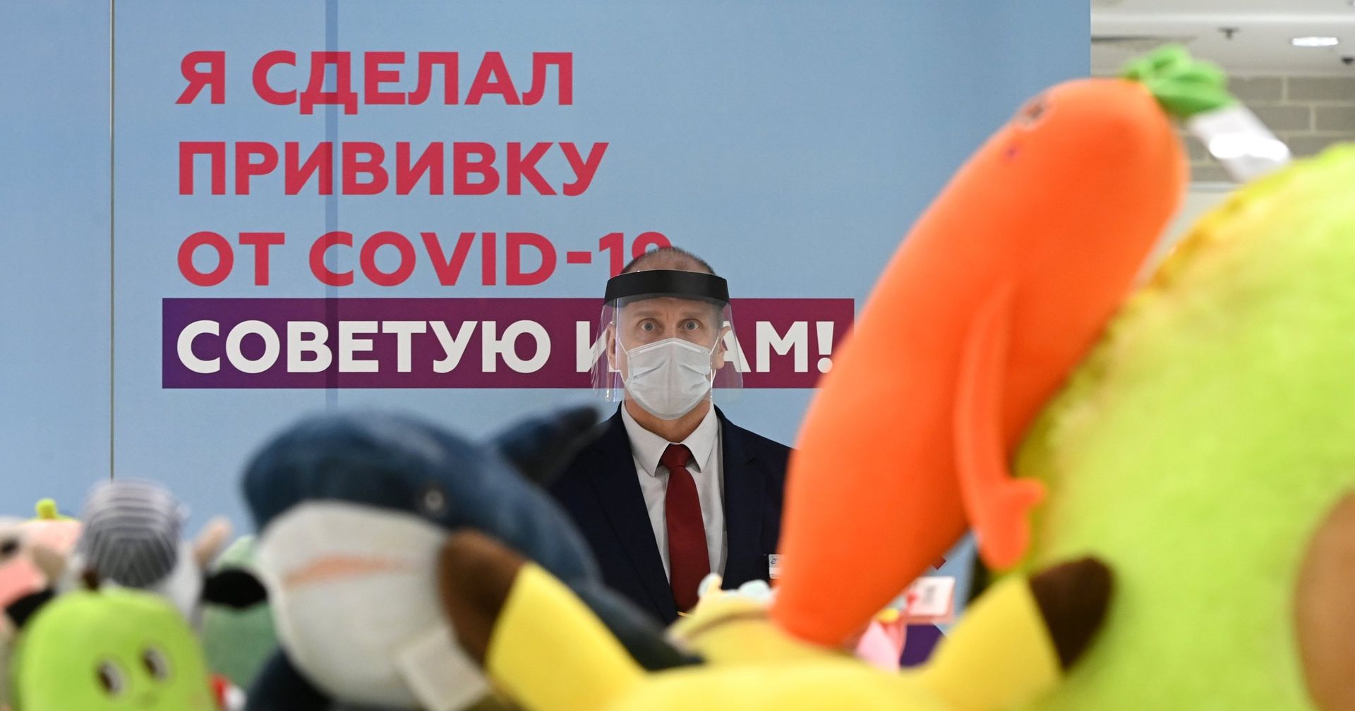 Сотрудник торгового центра «Европейский» возле агитплаката у пункта вакцинации от коронавируса - ИноСМИ, 1920, 14.04.2021