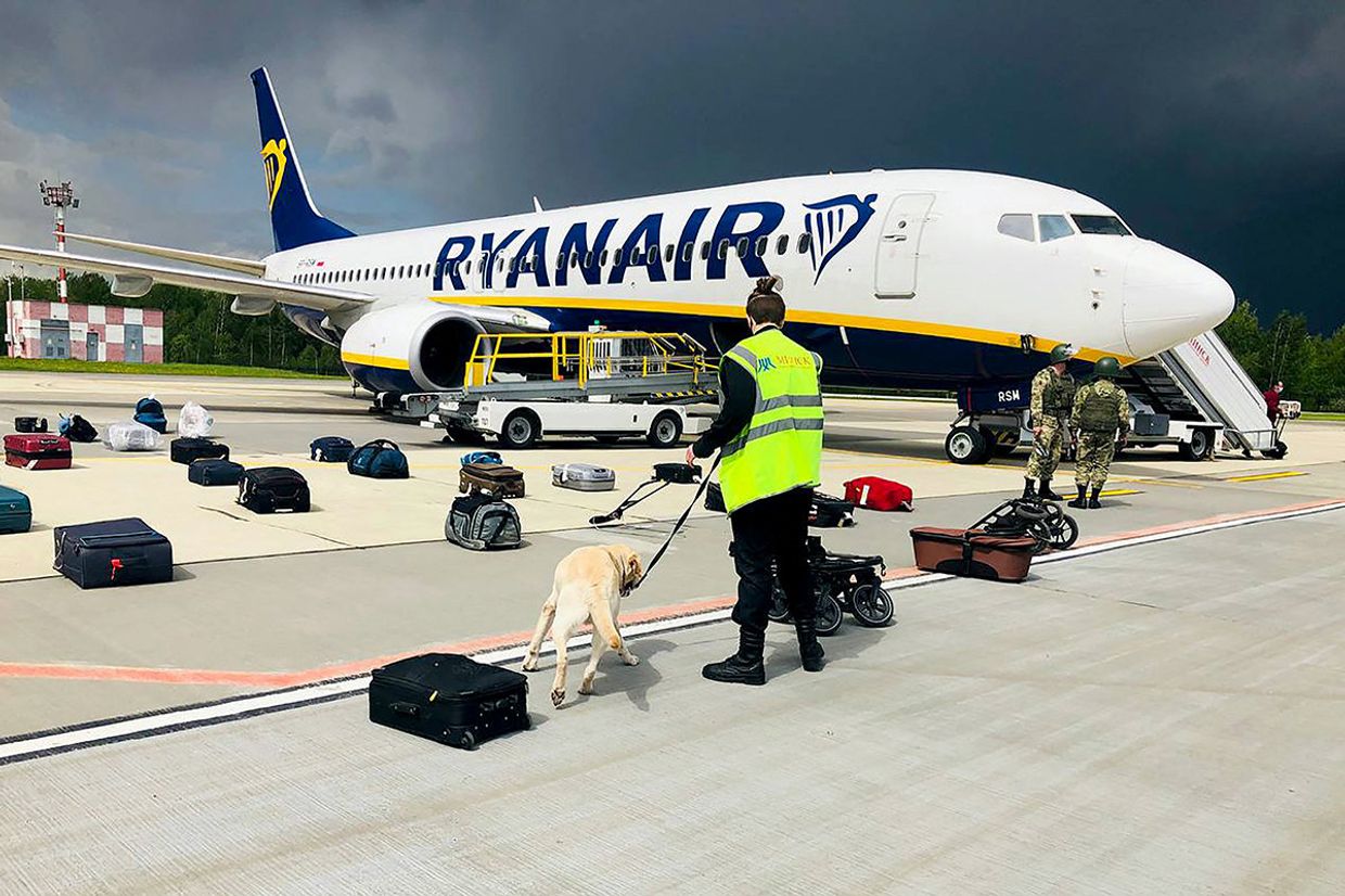 Кинолог проверяет багаж пассажиров самолета Ryanair Boeing 737-8AS на перроне международного аэропорта Минск