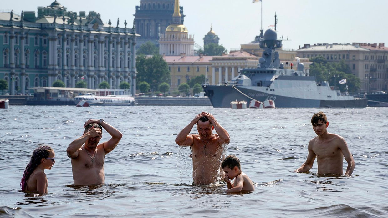 Люди купаются в Неве на пляже Петропавловской крепости в Санкт-Петербурге